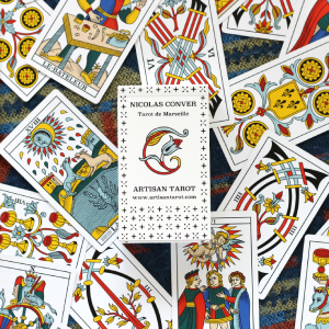 Photo of a box of tarot cards in the center with the cards scattered around it.