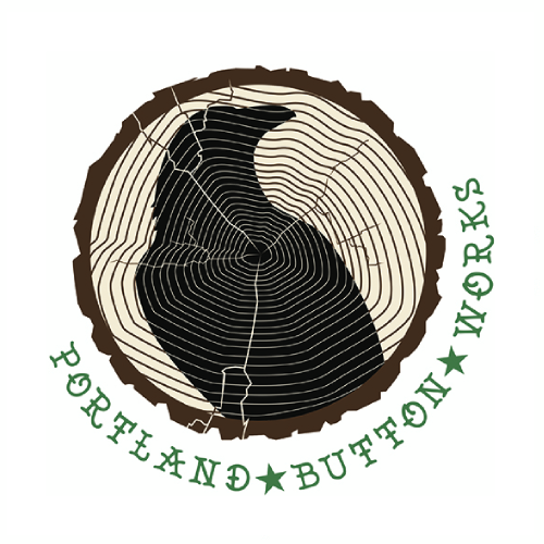 Logo: Portland Button Works with graphic of a slice of wood showing tree rings, with a black raven on the slice.