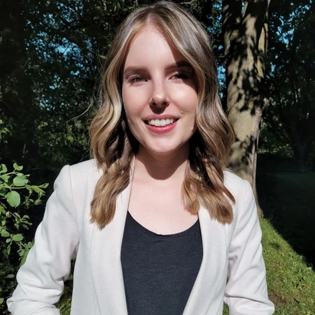 Photo of a woman with blonde hair wearing a white blazer.